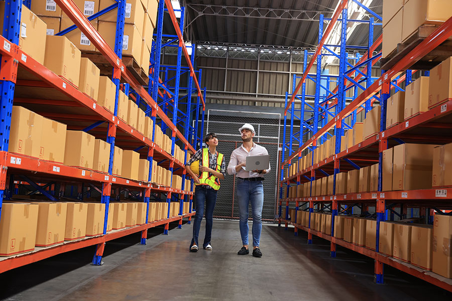 employee checking warehouse shelf in factory building