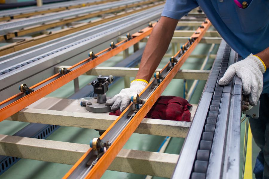 technician cleaning conveyor belt in food production line