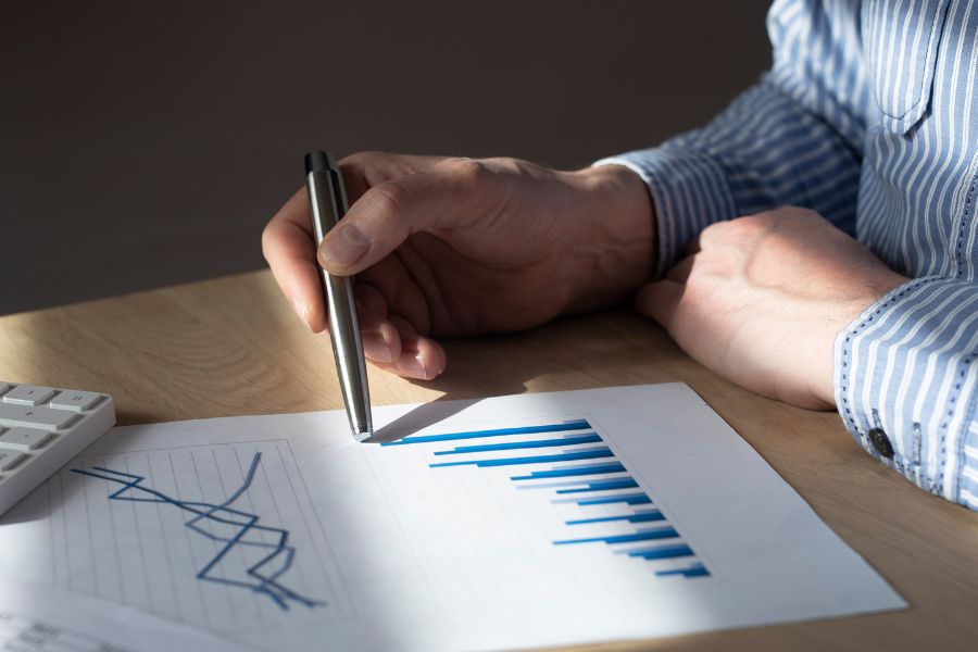 businessman at desk with financial documents and graph