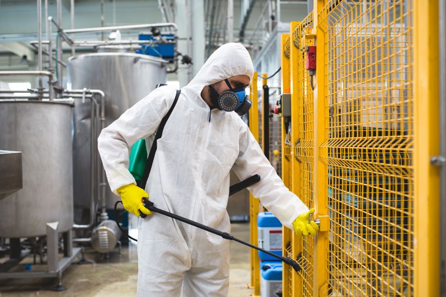 employee doing pest control on their production site