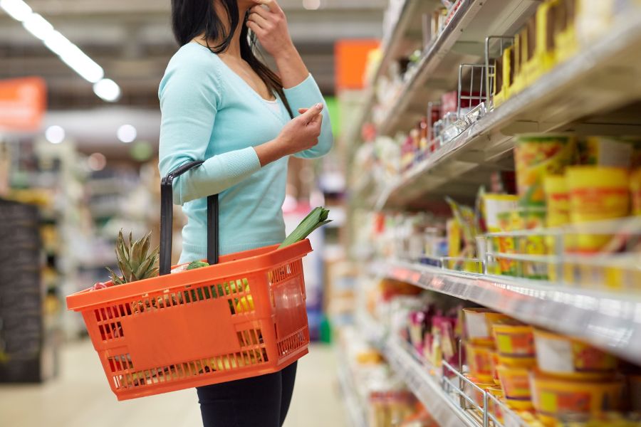 woman with food basket at supermarket