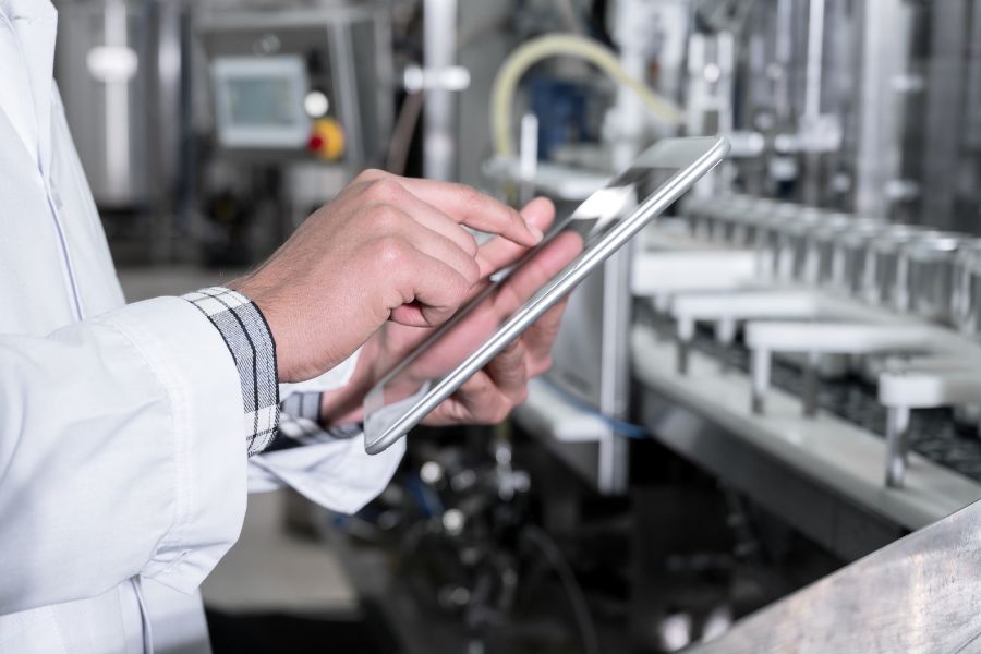 factory worker holding device inspecting production line