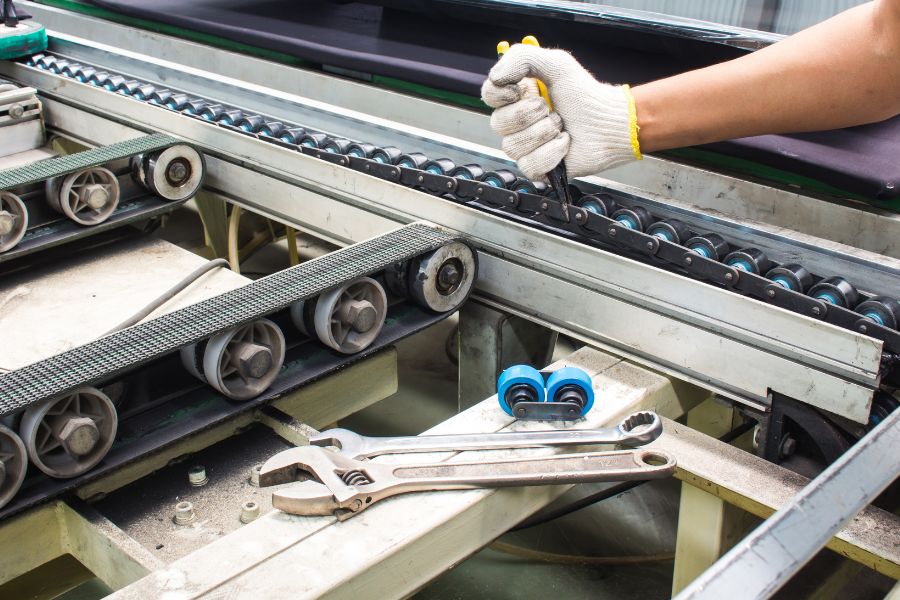 operator performing maintenance and repair on conveyor belt