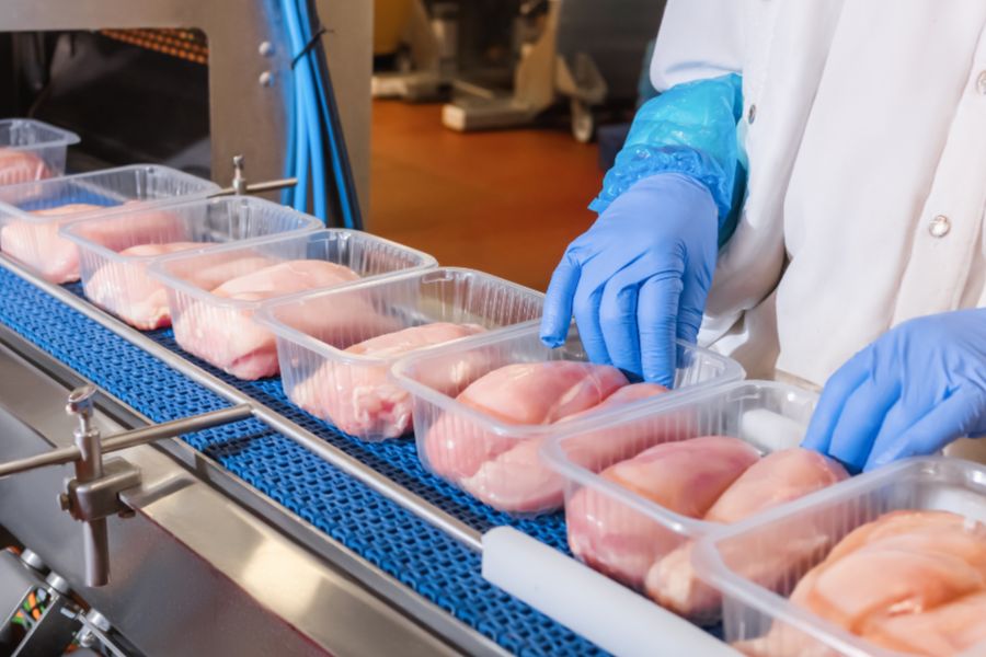 worker lining up meat products for weight checking