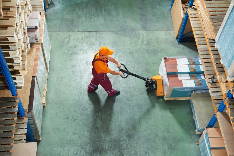 man lifting pallet with pallet jack